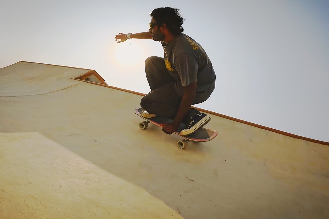 Skateboarder riding a ramp at dusk