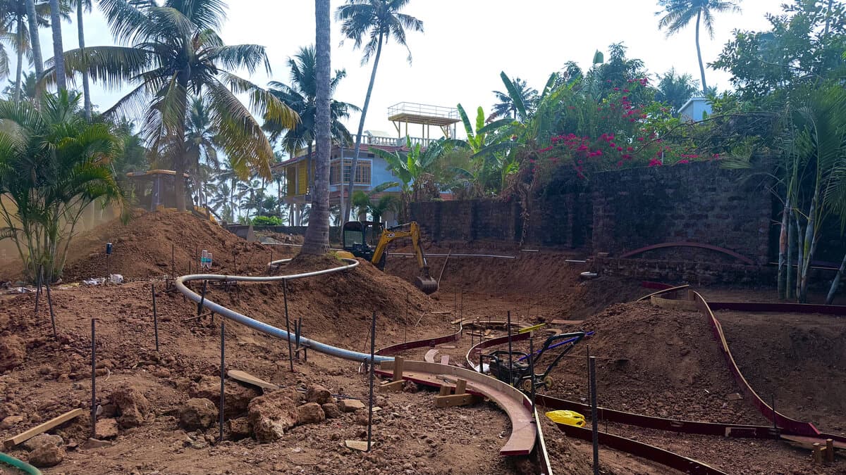 Skate bowl under construction with steel reinforcement among trees