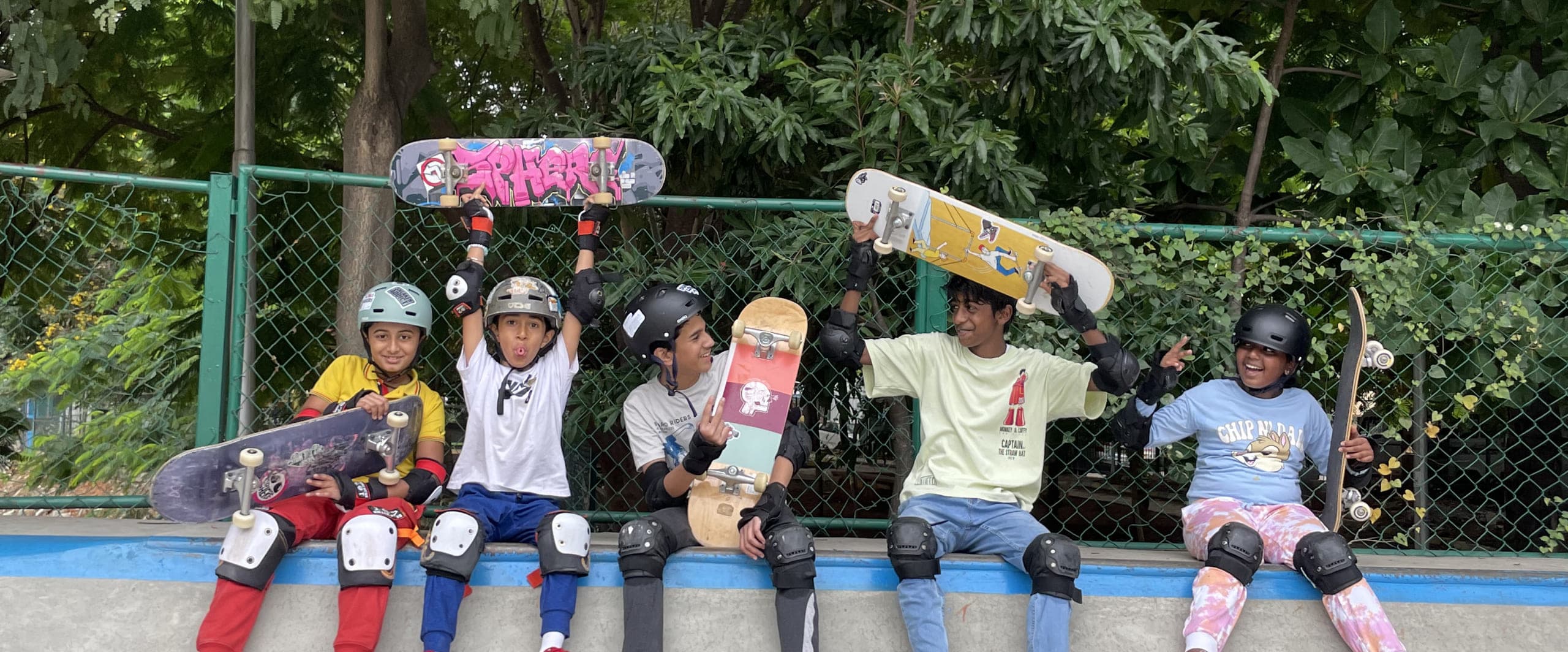 School students with skateboards wearing helmets and pads
