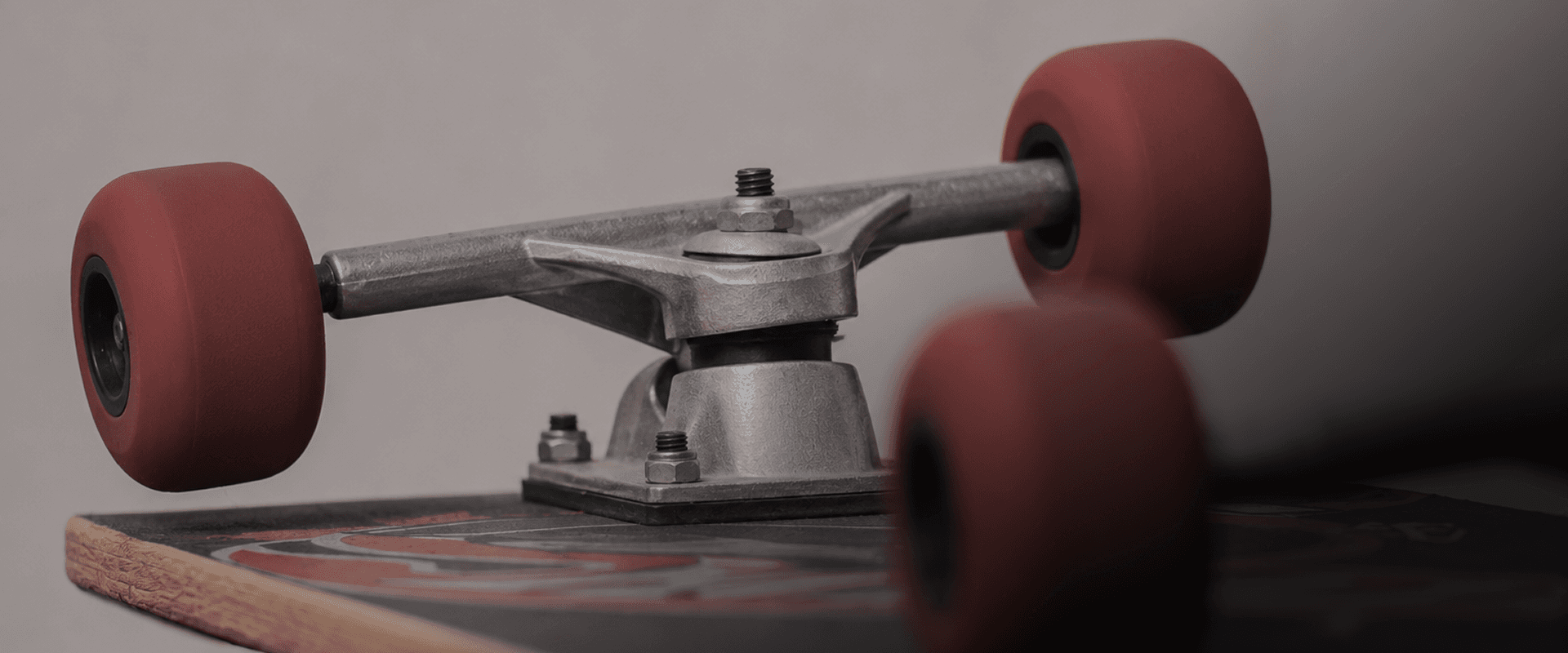 Close-up of a skateboard truck and red wheels